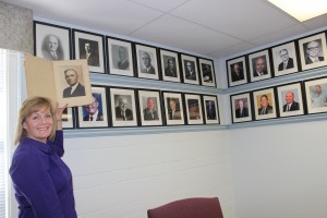 Executive Director Heather Richardson shows where the photo of Roy E. Warden will be placed as first president of the board of Arkansas State Board of Licensure for Professional Engineers and Surveyors